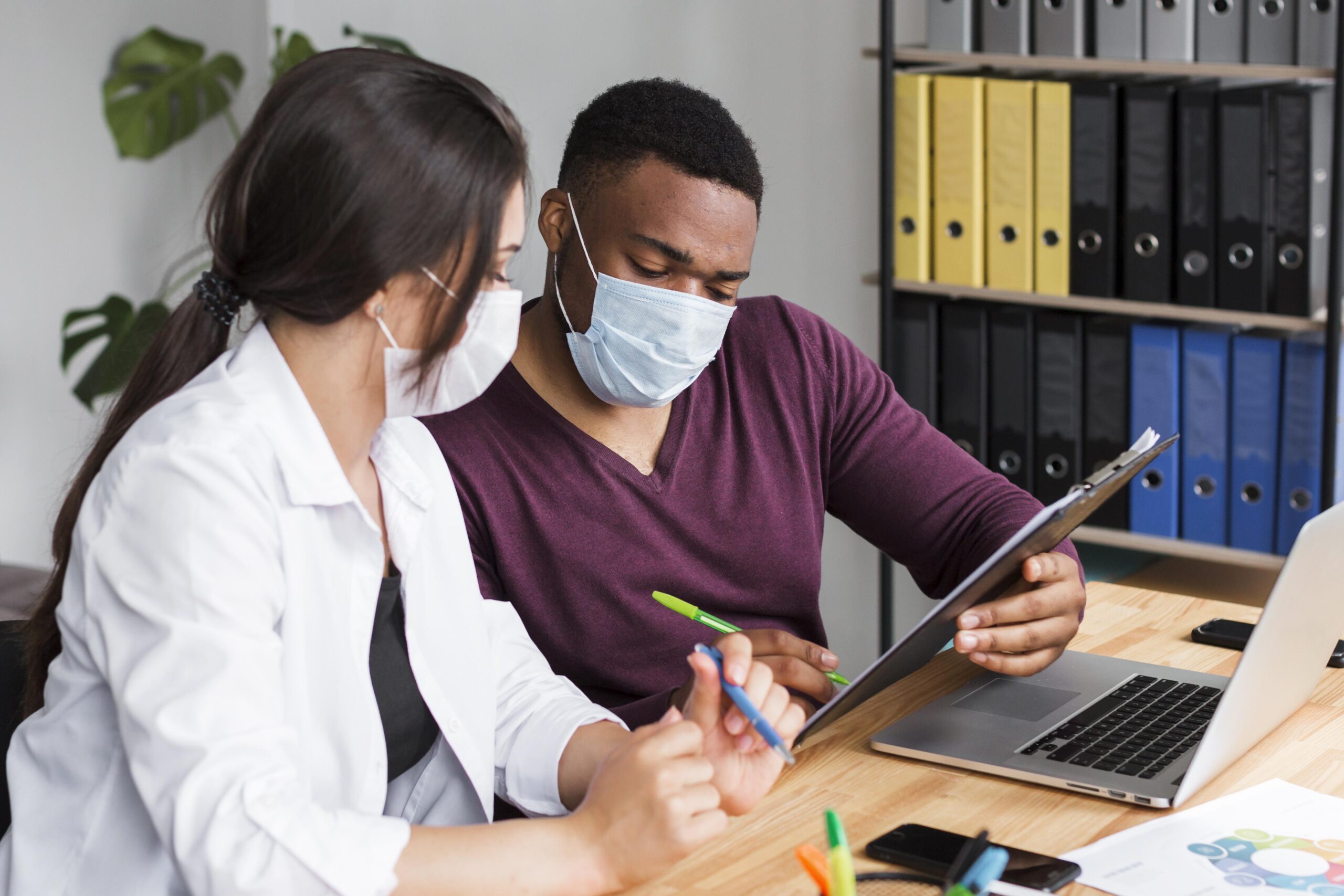 Two employee filling out a form for vaccine trial